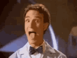 a man in a bow tie is sticking his tongue out and making a funny face .