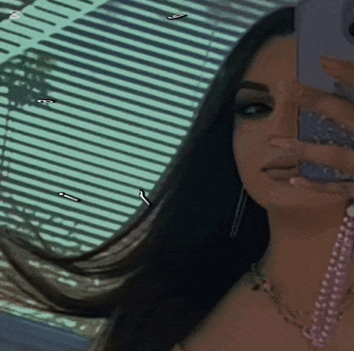 a woman is taking a selfie in front of a window .