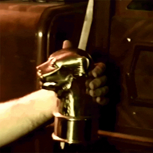 a close up of a person holding a gold object