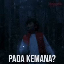 a person in a red vest is holding a flashlight and says " pada kemana "