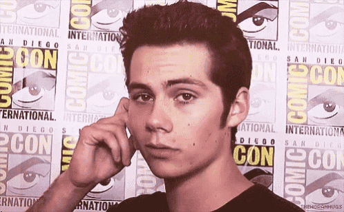 a man is standing in front of a comic con sign