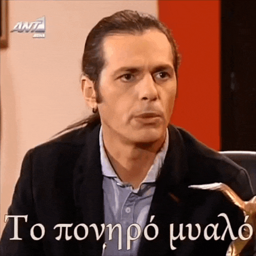a man with a ponytail is sitting in front of a ant logo
