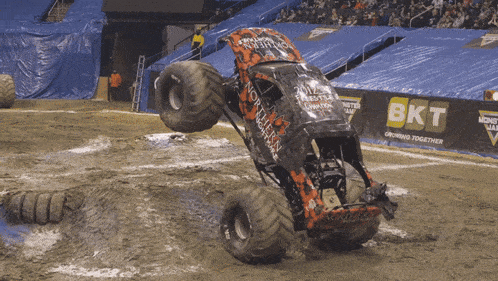a monster truck is jumping in the air in front of a sign that says bkt
