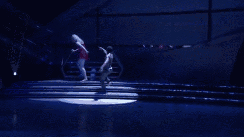 a man and woman are dancing on a stage .