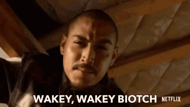 a man with a mustache is standing under a ceiling and says wakey wakey biotch netflix .