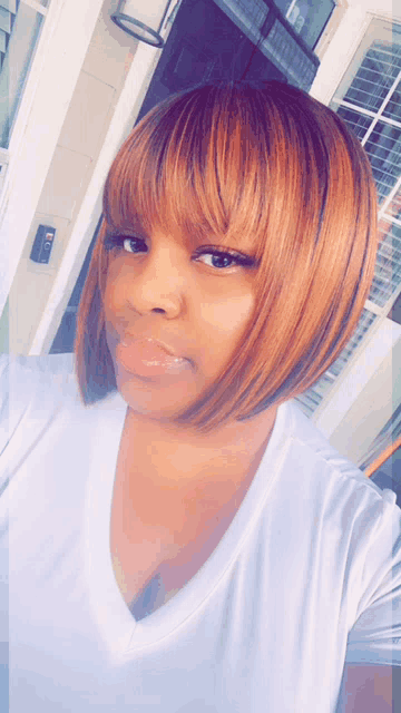 a woman wearing a white shirt and a wig with bangs takes a selfie