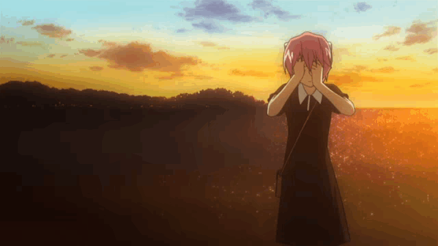 a girl with pink hair covering her face with her hands in front of a sunset