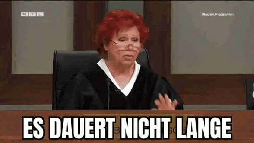 a woman in a judge 's robe is sitting at a desk with the words es dauert nicht lange written on the bottom
