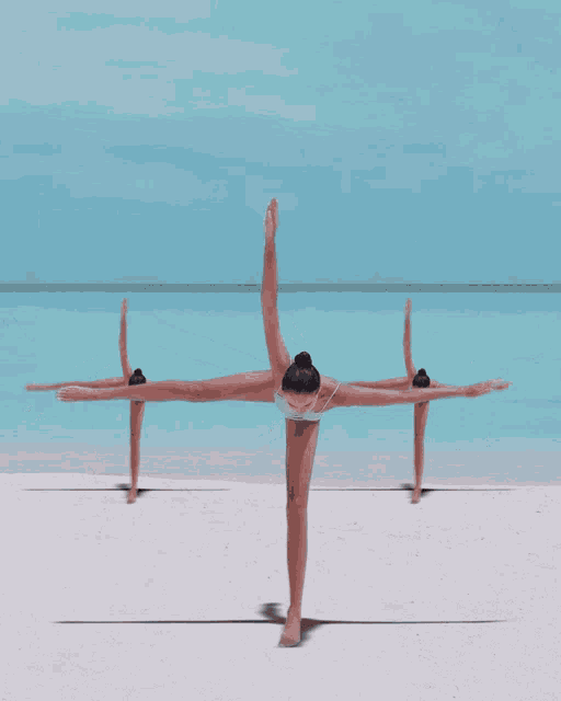 a group of women are dancing on a sandy beach