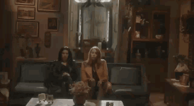 two women are sitting next to each other on a couch and hugging each other .