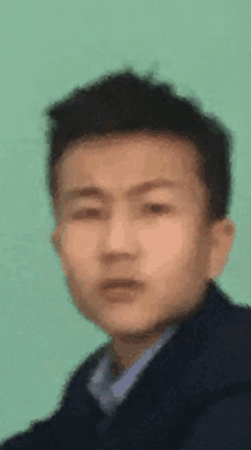 a blurry picture of a young man 's face against a green background