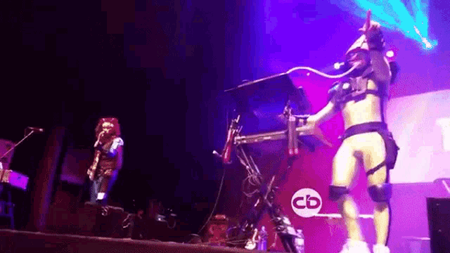 a woman is dancing on a stage in front of a keyboard and a sign that says cb .