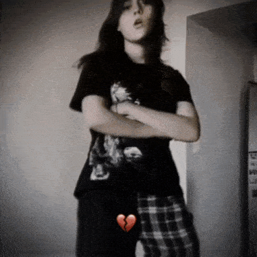 a girl in a black shirt with a broken heart on her leg