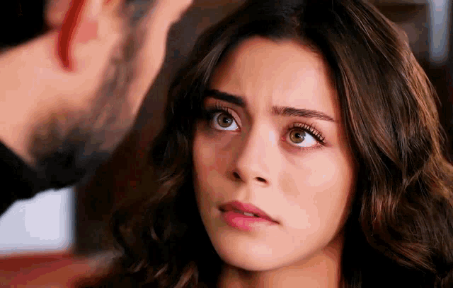 a man and a woman are looking at each other . the woman has a serious look on her face .