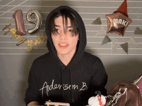 a man wearing a black hoodie that says ' aderisem b ' on the front