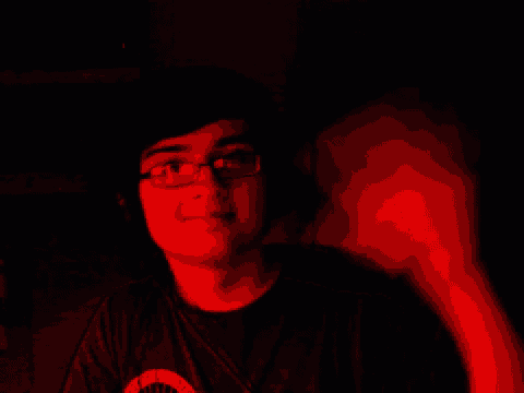 a young man wearing glasses and a black shirt with a circle on the front