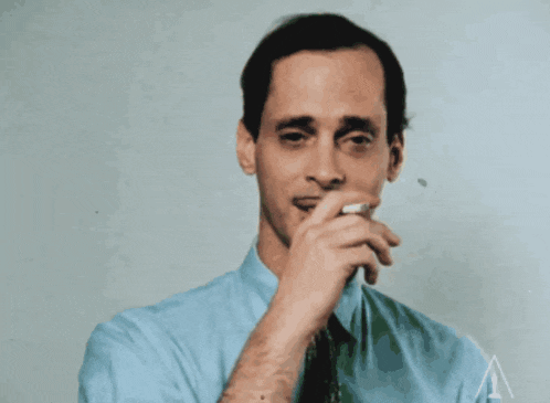 a man in a blue shirt and tie is smoking
