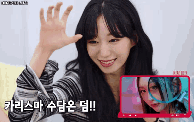 a woman is smiling and waving her hand in front of a screen that says honeycam.org on it