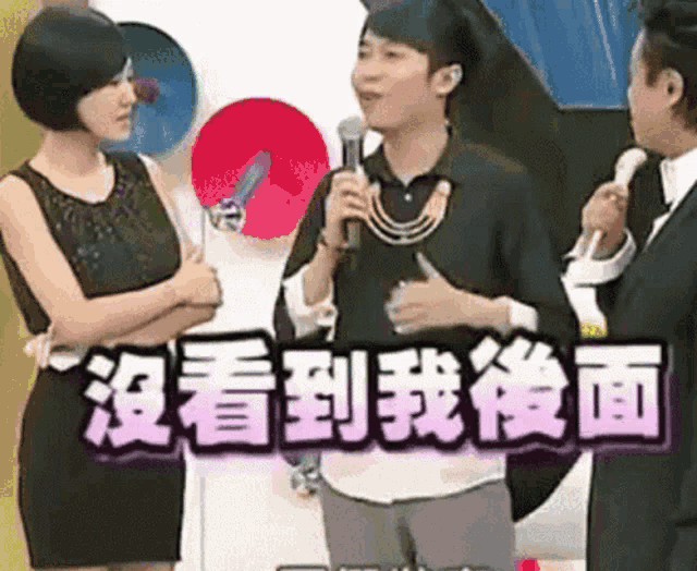 a man speaking into a microphone next to a woman with chinese writing on the bottom