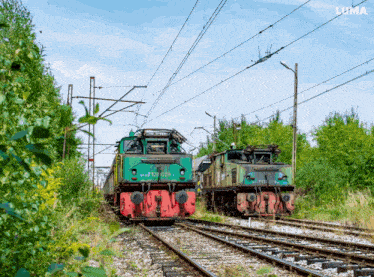 two trains are on the tracks with the word luma on the bottom right