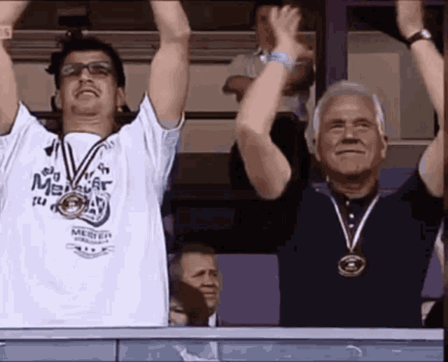 a man wearing a shirt that says ' meister ' on it holds his arms in the air