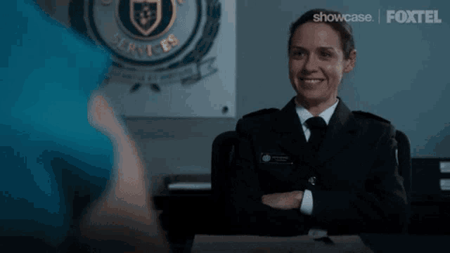 a woman in a police uniform says oh you 're serious while sitting at a desk