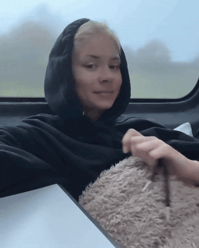 a woman in a black hoodie sits at a table