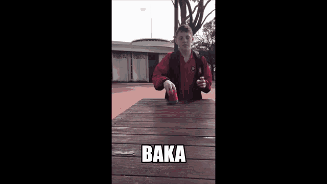 a person sitting on a wooden deck with the word baka on the ground