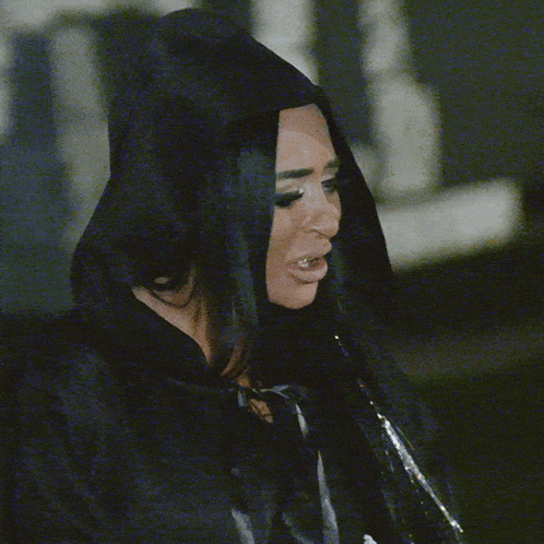 a woman is wearing a black hooded jacket