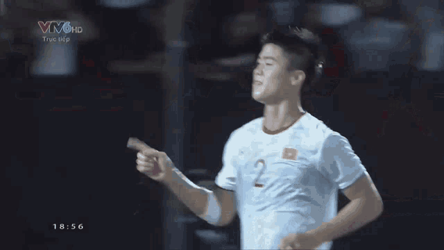 a man in a white shirt is giving the middle finger in front of a banner that says vivohd