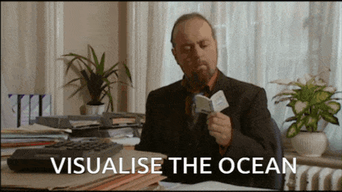 a man sitting at a desk reading a book with the words visualise the ocean above him