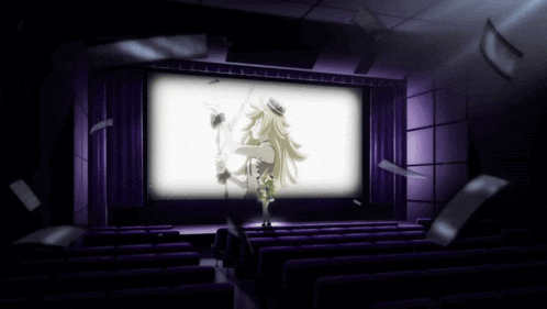a woman in a hat stands in front of a large screen in a theater