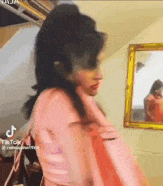 a woman is standing in front of a mirror in a room .