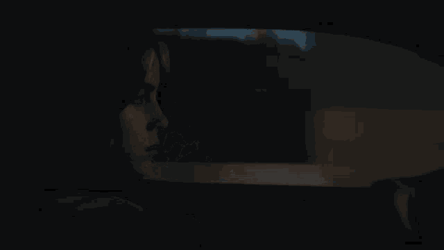 a woman is sitting in the back seat of a car at night looking out the window .