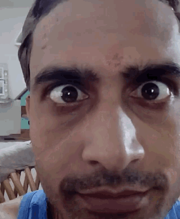 a man with a beard is making a funny face with his eyes wide open