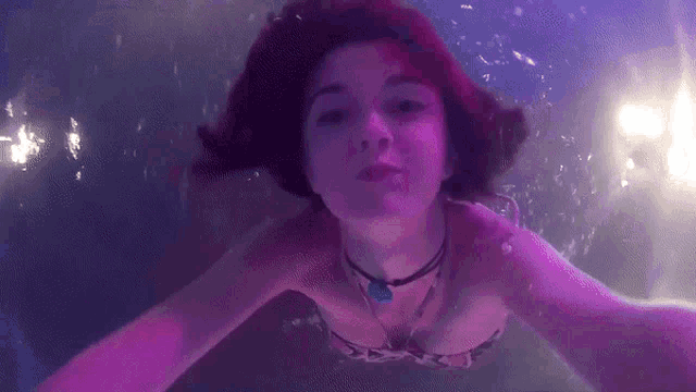 a woman with red hair is swimming underwater