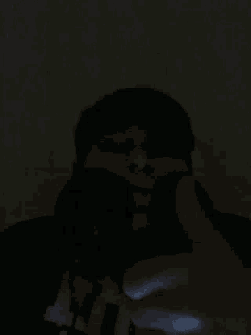 a man in a black shirt is holding a black object in his hand .
