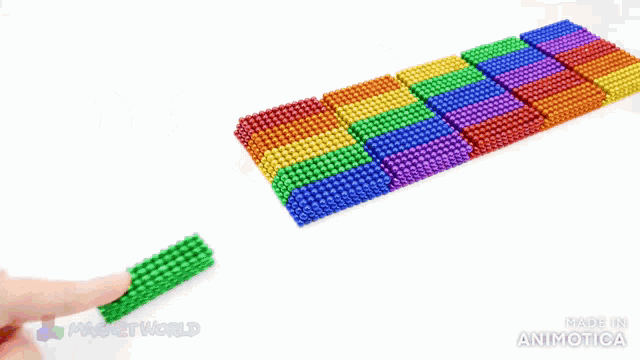 a person is playing with a rainbow colored bracelet made by magnet world
