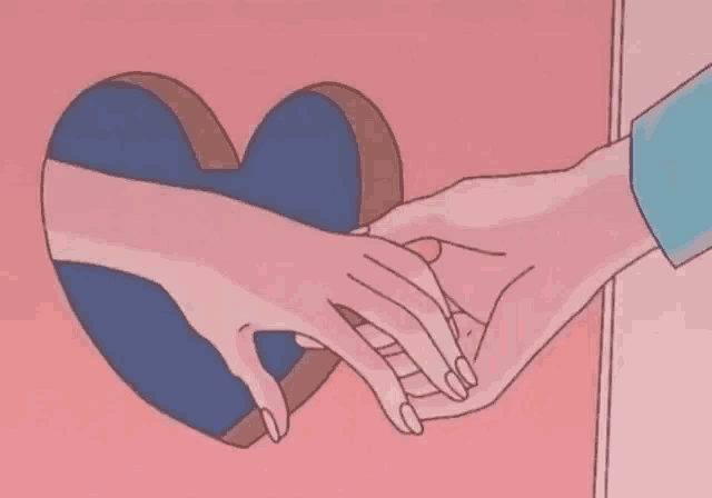 a couple of hands holding a heart shaped pillow