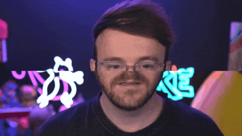a man with glasses and a beard stands in front of a neon sign that says ke