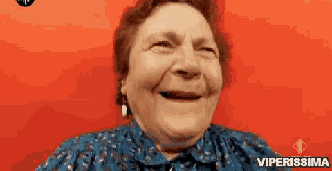 an elderly woman is smiling and making a funny face .