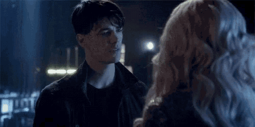 a man and a woman are standing next to each other in a dark room .