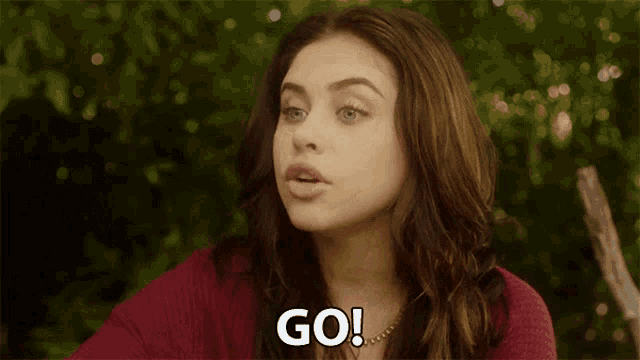 a woman in a red sweater says go