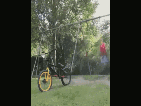 a bicycle is sitting on a swing set in a yard