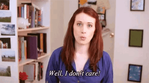 a woman with red hair is standing in front of a bookshelf and saying `` well , i don 't care ! ''