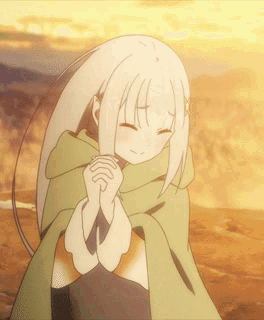 a girl with white hair and a green cape is praying with her eyes closed