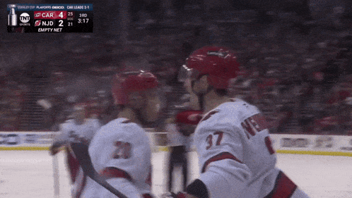 a hockey player wearing a number 37 jersey hugs another player