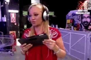 a woman wearing headphones is holding a tablet in her hand .