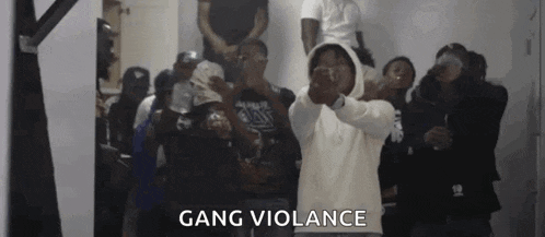 a group of young men are standing in a room with guns in their hands and the words gang violence written on the bottom .