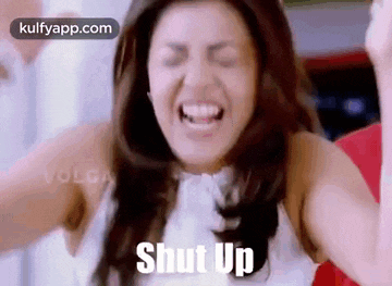 a woman is screaming with her eyes closed and the words `` shut up '' written on the screen .